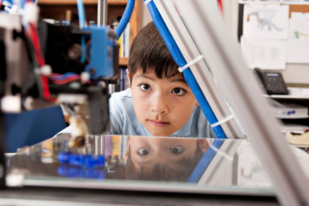 boy watches 3d printer