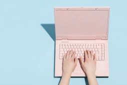typing on pink laptop