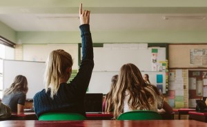 student raising hand in classroom