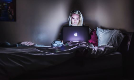 woman with laptop in bed