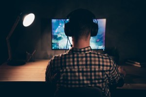 guy with headphones playing a computer game