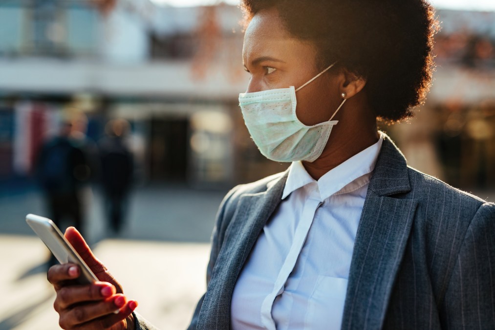 woman with mask and smartphone