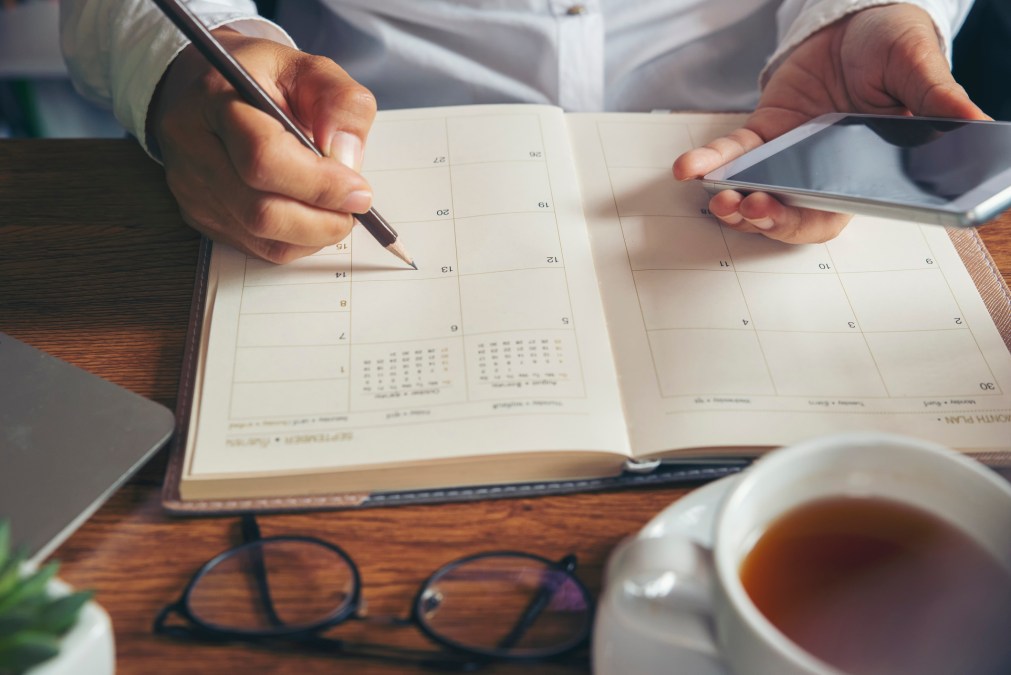 person looking through schedule with phone