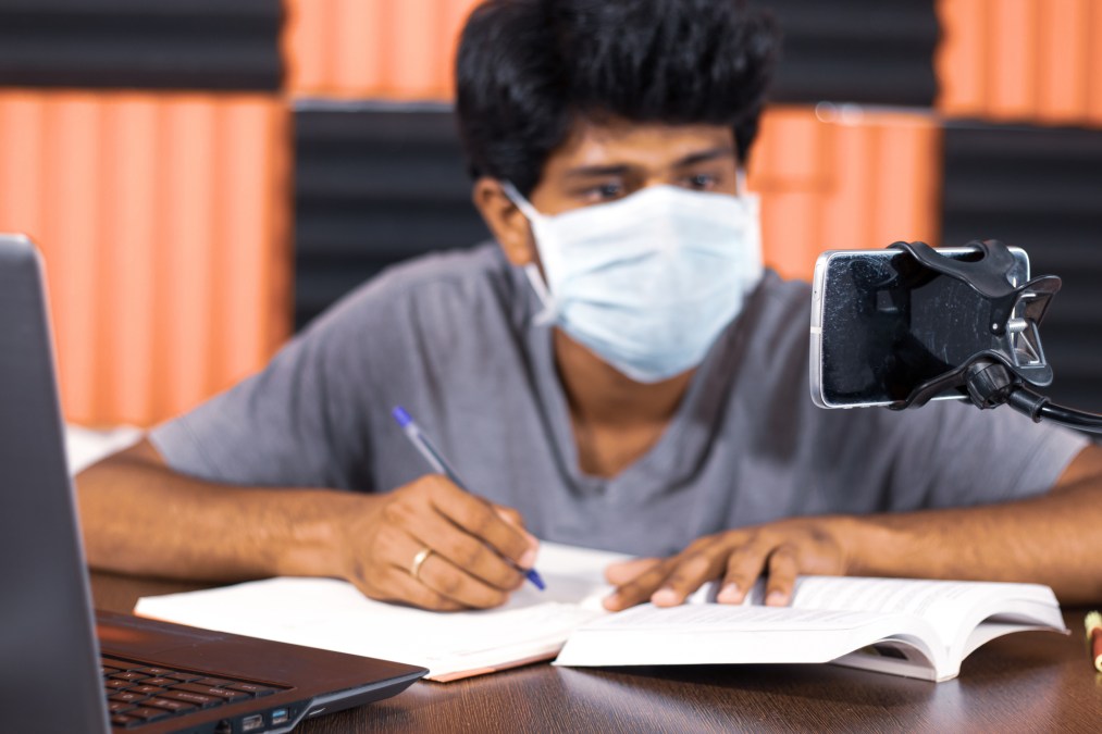 young man studying with mask