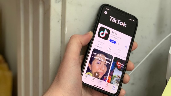 hand holding phone with TikTok app opened