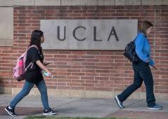 people walking past UCLA sign