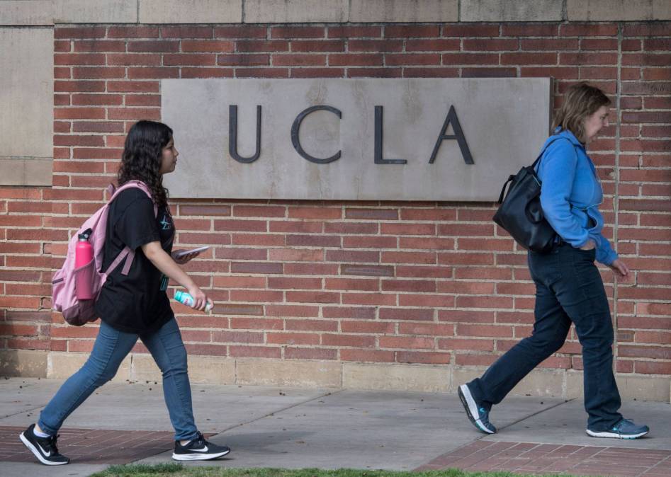 people walking past UCLA sign