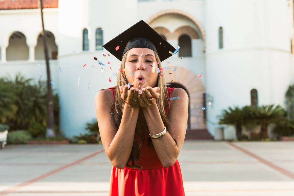 graduate blowing confetti out of hands