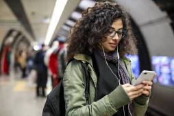 woman on smartphone on subway platform