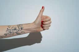 woman's arm thumbs up