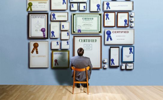 Businessman staring at certificates on wall